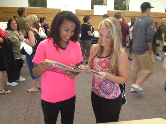 Two students looking at book during Freshman Registration and Family Orientation.