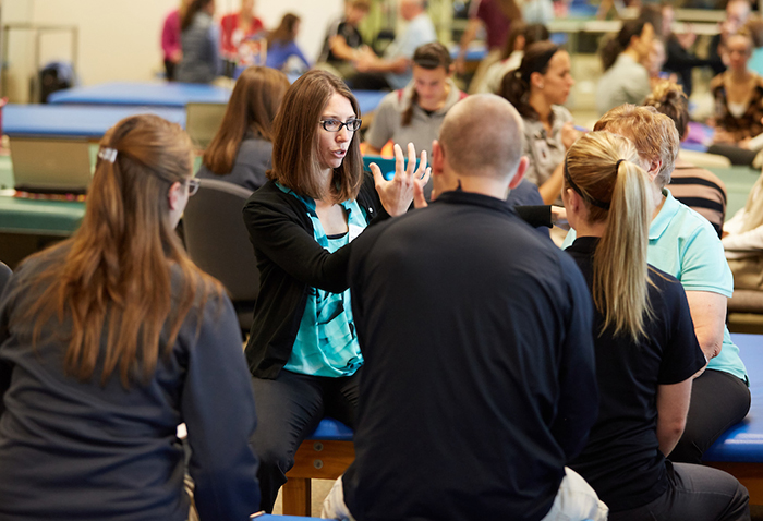 Image of Heather Fortuine teaching a group of student seated around her.
