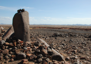 Image of a large stone structure amid a desert area. 