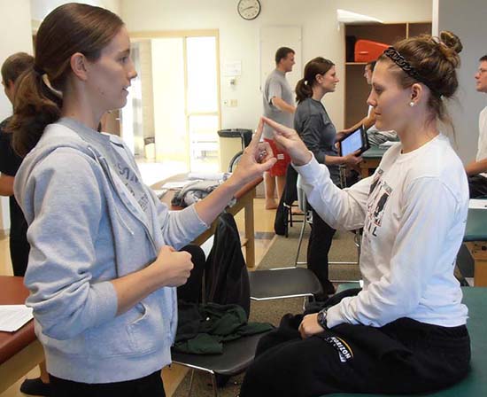 Two PT students with fingers touching - an examination skill.