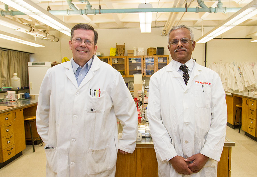 Image of Microbiology Professors Mike Winfrey and S.N. Rajagopal standing together in lab coats.
