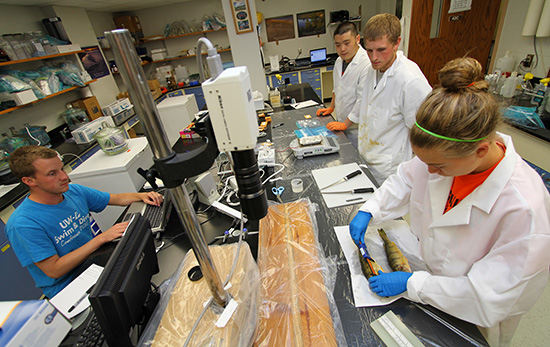 Student measuring fish in the lab. 