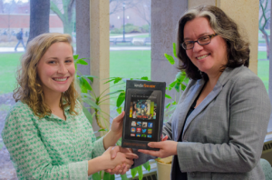 Image of  Allison McDonald,receiving the grand prize, a Kindle Fire HDX tablet, from Catherine Lavallée-Welch, library director.