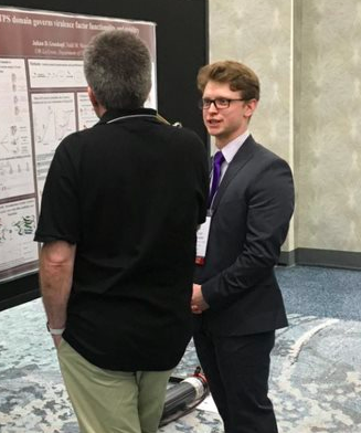 Julian talking to someone who is viewing his poster.