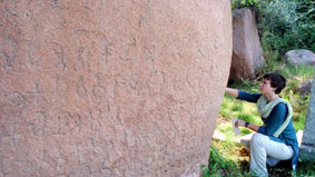 Image of person working by large stone.