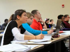 Students in a class taking notes. 