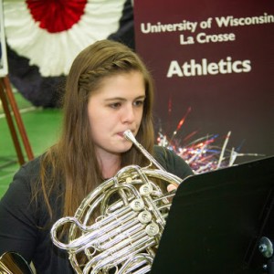 Female student playing a french horn. 
