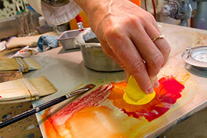 Dipping yellow into red with fingers. 