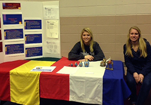 Two students sitting at a booth at School of Education Take a Look Day. 
