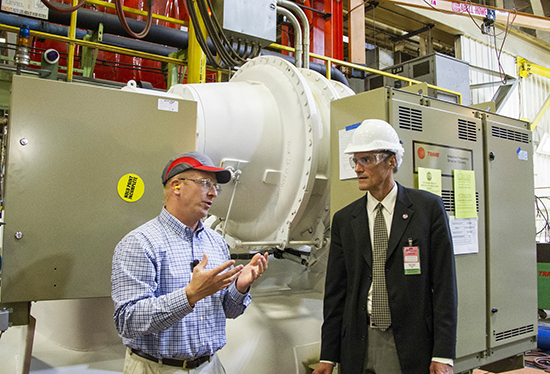 Ryan Geister,'00, a Trane employee, left, shows a completed chiller to UW-L Chancellor Joe Gow.