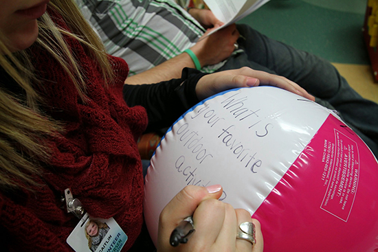 student writing words on a beach ball - "What is your favorite color? 