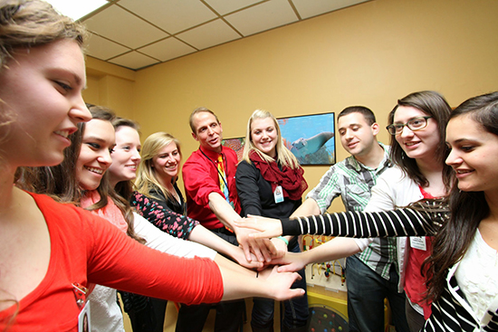 Students and Jeff Reiland all put their hands in together. 