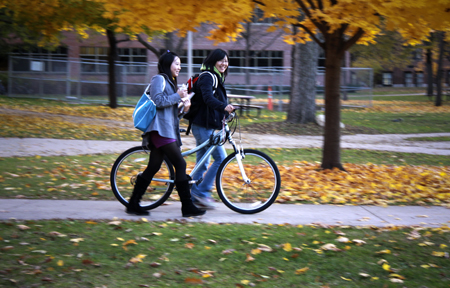 Two students walking with bikes