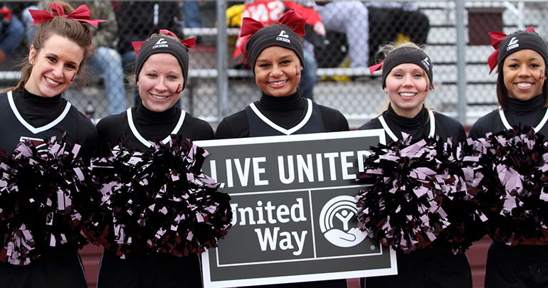Cheerleaders holding United Way sign. 