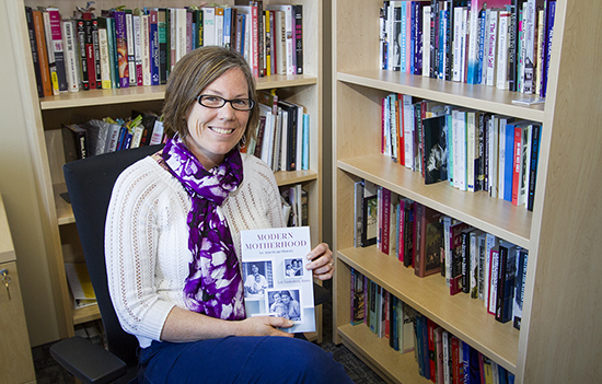 Image of Jodi Vandenberg-Daves sitting in front of a bookshelf. 