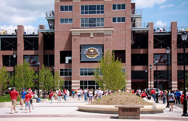 Image of the outside of the Veterans Memorial Field Sports Complex with people walking. 