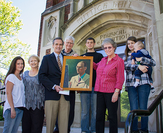 Wittich family and UW-L Chancellor Joe Gow pose in front of Wittich Hall.