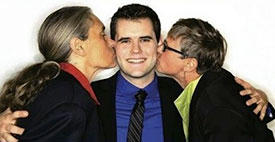 Zach Wahls in middle getting kissed by two moms.