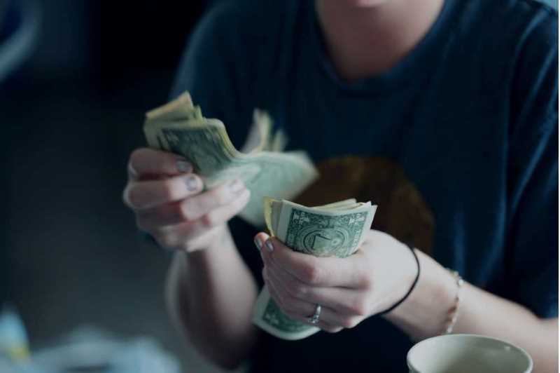A person holds cash in hands.