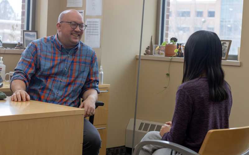 Luke Fannin, ’09, director of Student Support Services, meets with UWL Senior Amanda Keil, an SSS student.