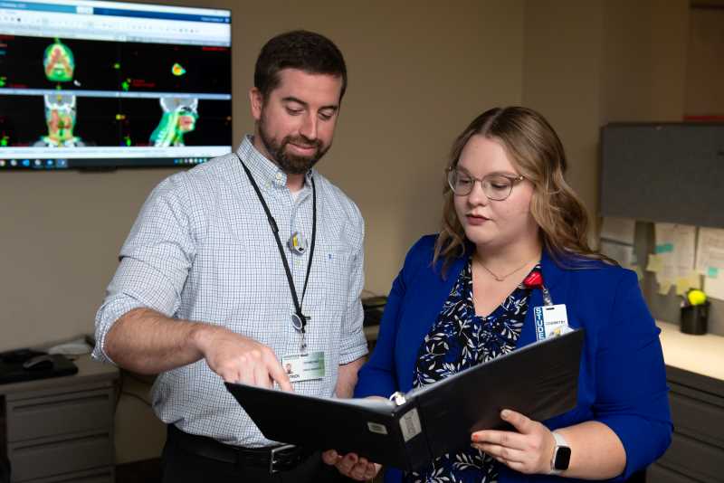 Medical Dosimetrist Patrick Melby graduated from UWL with a degree in Nuclear Medicine Technology in 2012, applied for the medical dosimetry program in 2014 and was in the program 2015-2016.  He now mentors UWL graduate student Paige Solie. “It is fun to watch a student — to watch the light bulb go on when they understand the concept,” he says.  Photo courtesy of Gundersen Health System.