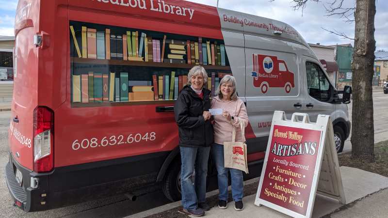 Mary Mulvaney-Kemp (left) in front of RedLou Library, a mobile library she created to serve Viroqua-area residents. Mulvaney-Kemp, ’82, hopes the library will create more equal access to reading materials in the community.