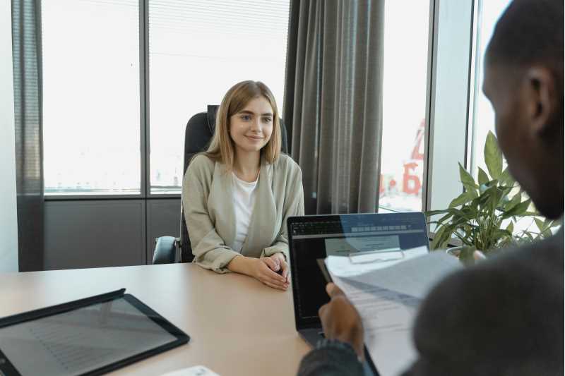 A job candidate sits across from an interviewer reviewing their resume.