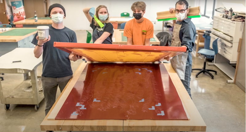 UWL students and faculty member in the art studio posing with a piece of the installation.