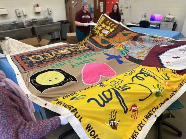 UWL students conduct a “condition report” of panels from the AIDS Memorial Quilt that will be exhibited on campus. Quilt panels were last on campus in 1994. 