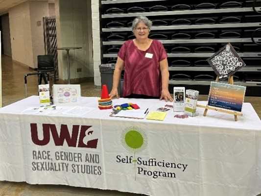 Back to school is for grown-ups too!  Andrea Hansen, standing behind her table displaying educational materials at the La Crosse Center school supply drive