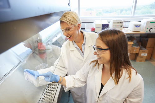 Microbiology student and professor working at fumigation hood