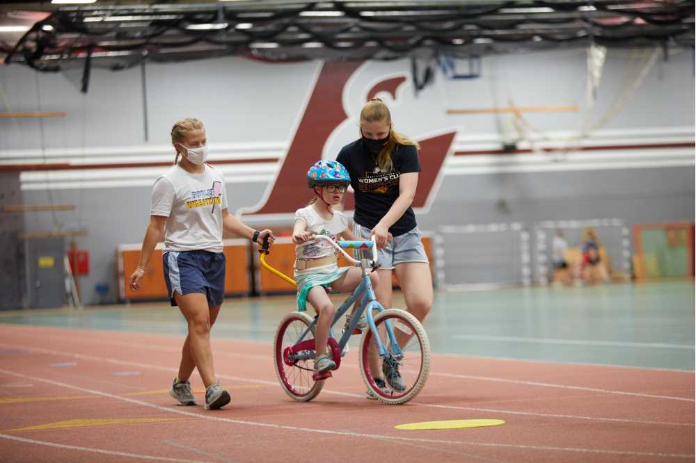 Students walking with youth on bike