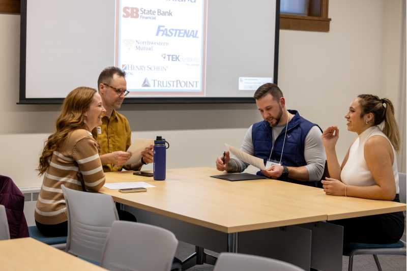 Students working together at a table during the UWL Eagle Sales Competition