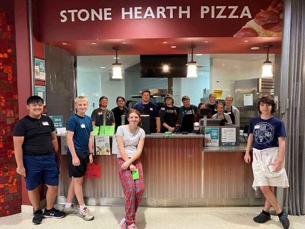Pizza Project youth camp participants pose in front of the 'pop-up' restaurant Stone Hearth Pizza