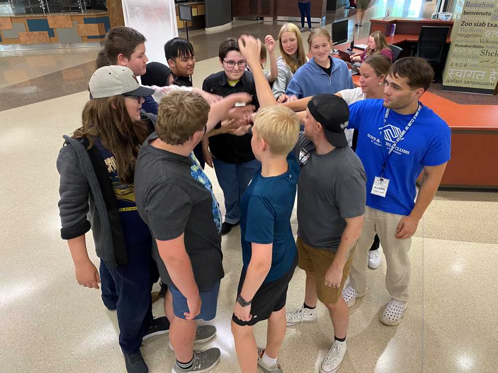 Pizza Project youth campers in a circle with hands united
