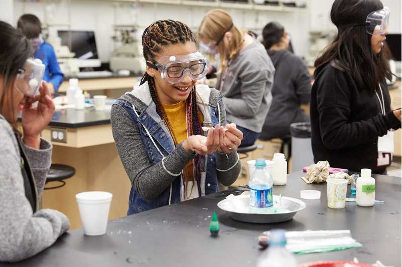 Female student wearing googles in science lab.
