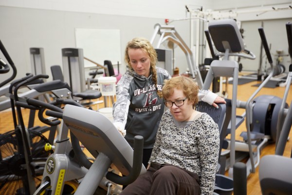 Adult lifts weights in the Strength center
