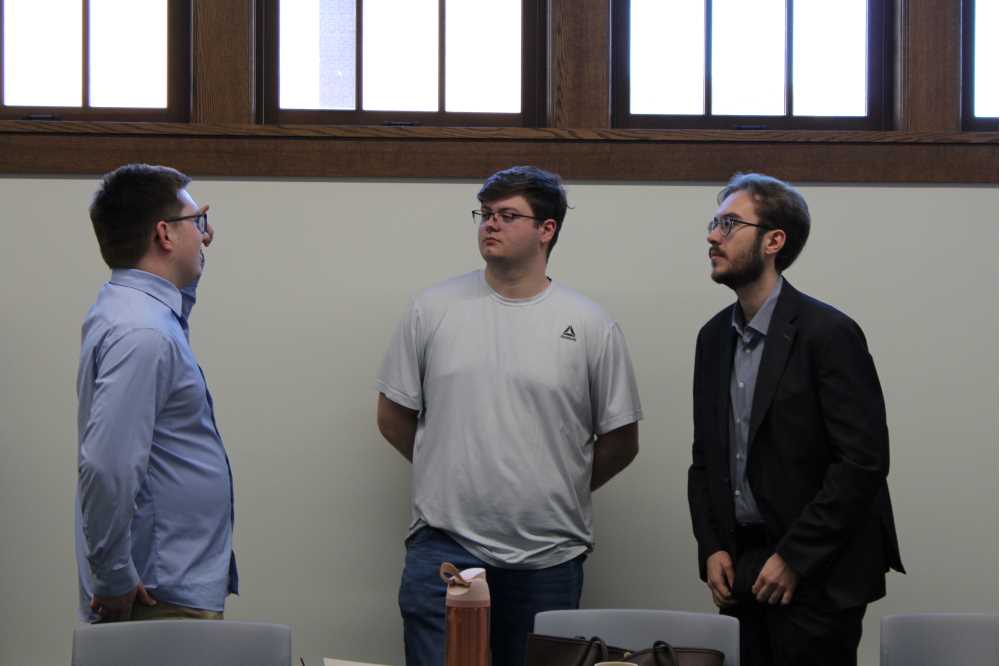 Ryan Kitzan, Blake Goodreau, and Joshua Schulze-Reimpell discussing the colloquium.