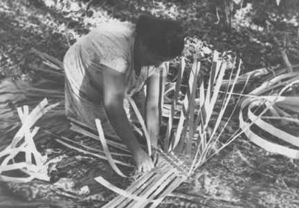 Mabel Lowe weaving the bottom of a basket.