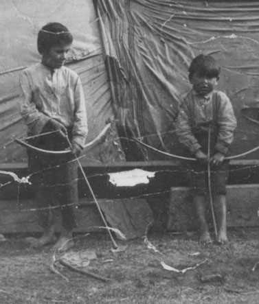 Unknown boys playing with bows and arrows