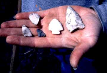 Hand holding projectile points. 