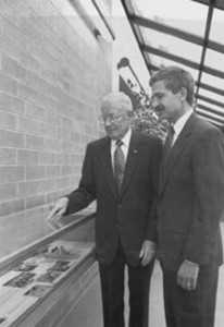 Two people looking at a display case.  