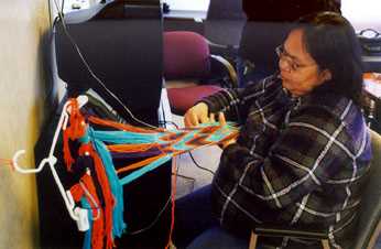 Linda Shegonee in the process of making a finger woven sash