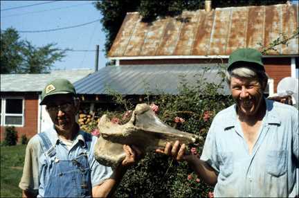 John and Otto Swennes holding the front leg bone of an Ice Age mastodon. 