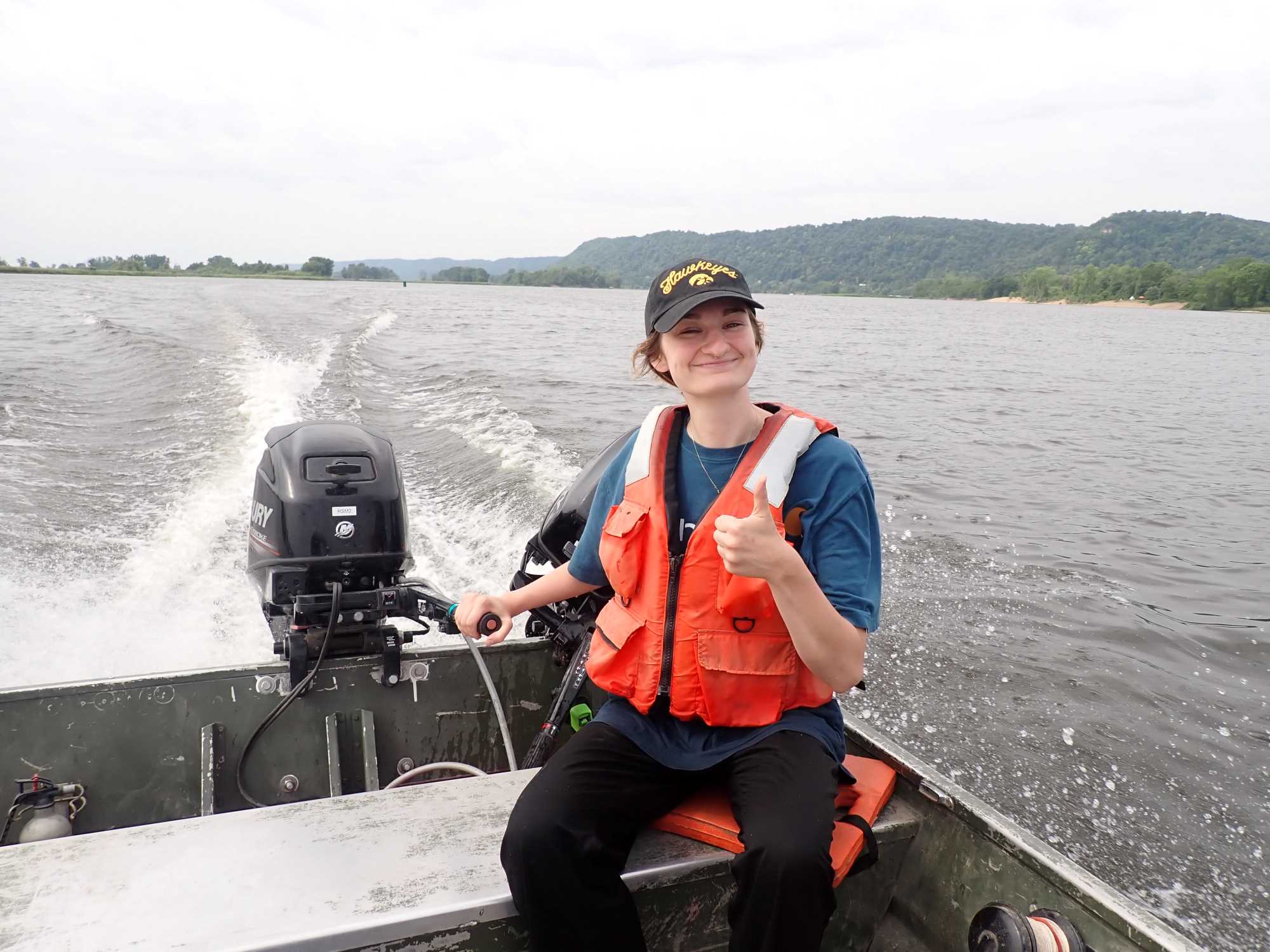 Graduate student driving flat bottom boat