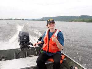 Graduate student driving flat bottom boat