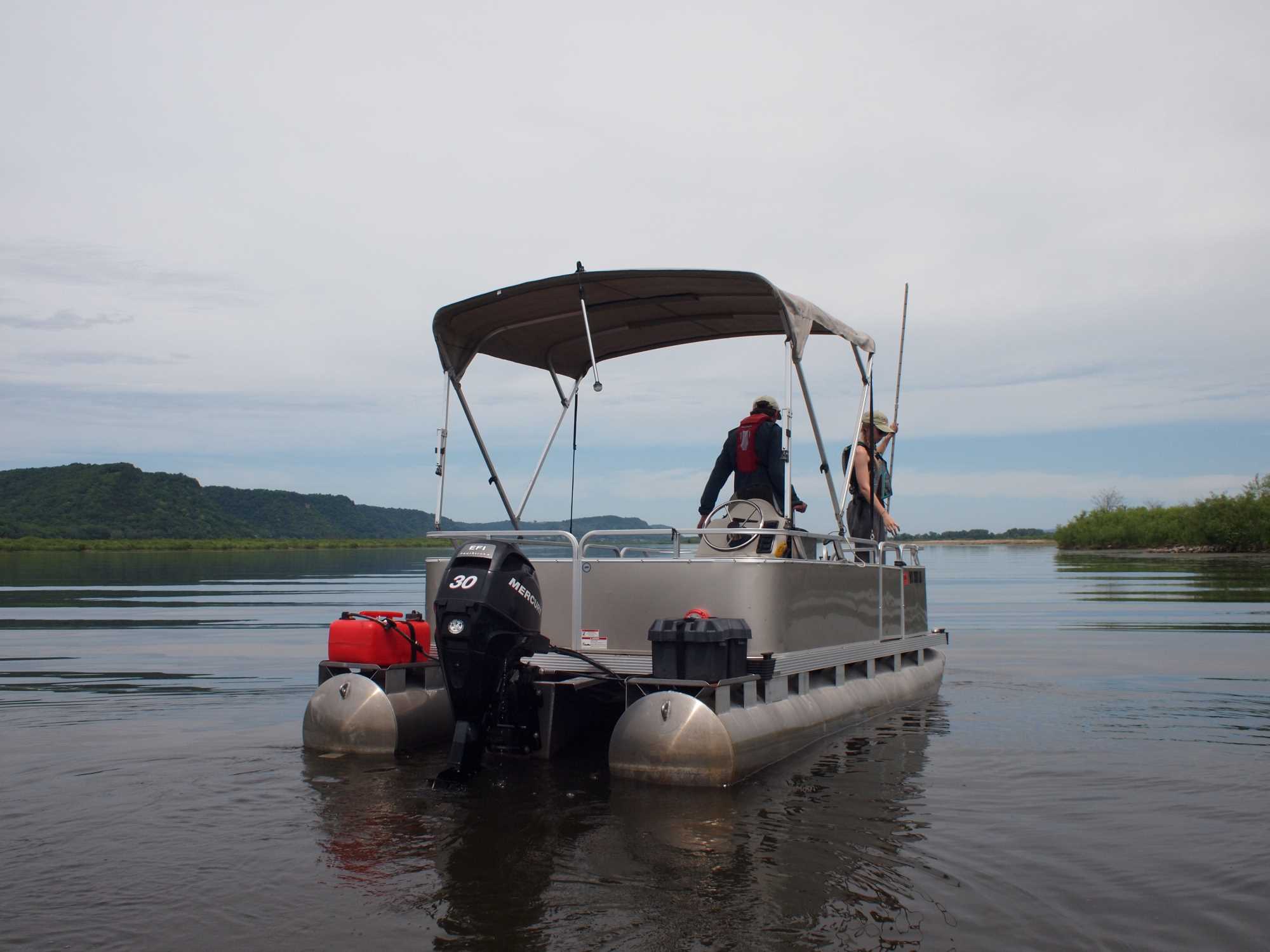 Graduate student and faculty on pontoon boat