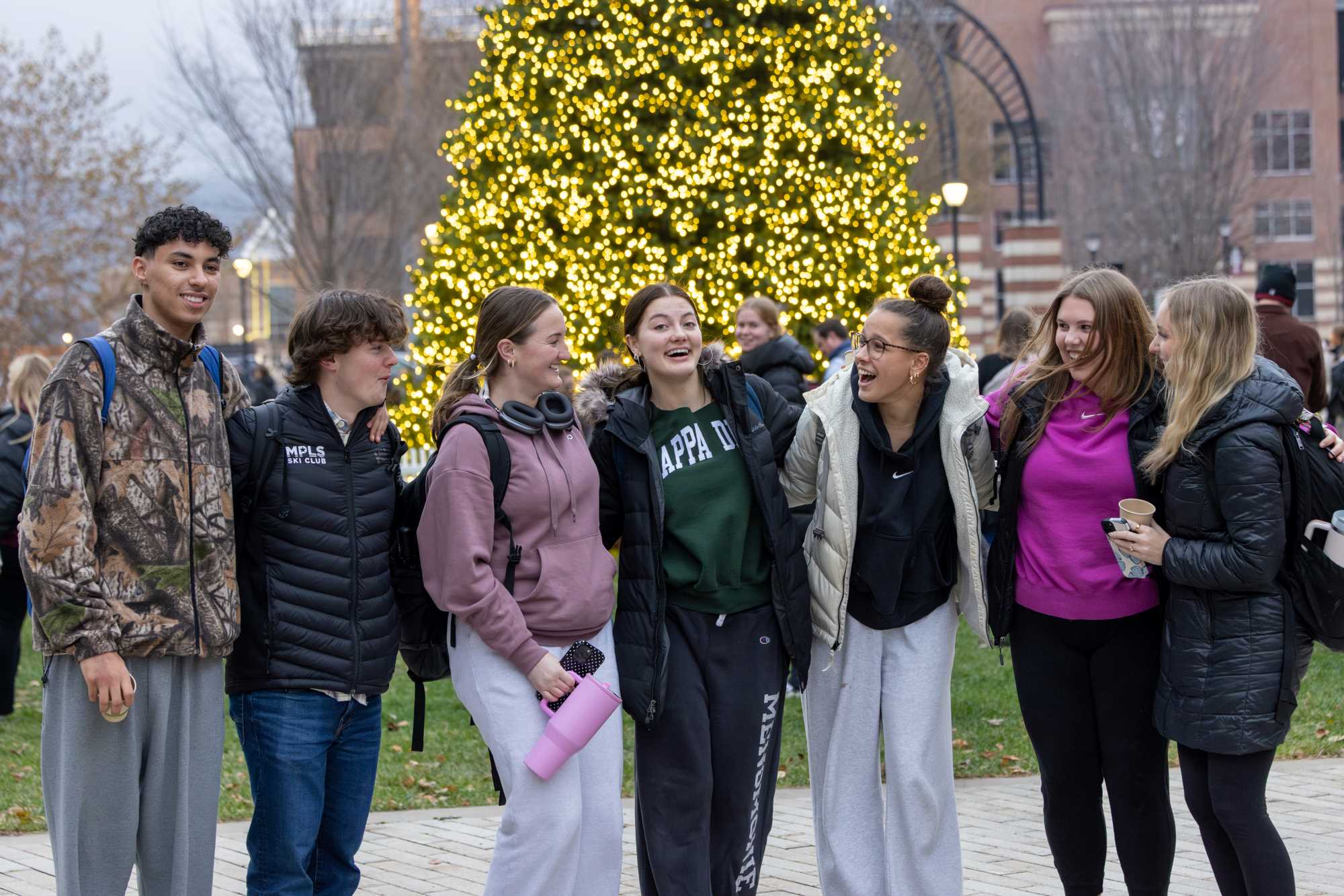 A group of students in front of the Campus Holiday Tree.