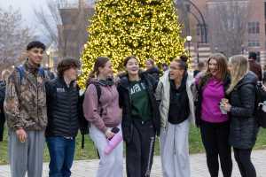 A group of students in front of the Campus Holiday Tree.