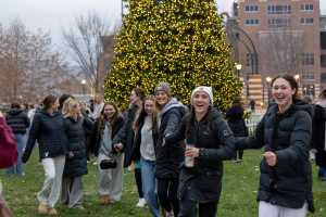 A group of students in front of the Campus Holiday Tree.